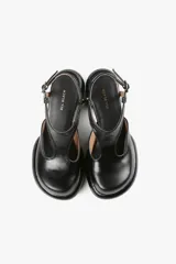 Zapato negro de cuero con pulsera al tobillo, taco ancho y plataforma con diseño redondeado.