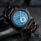 Reloj Chenaut Saphir d’Ébène con movimiento de cuarzo, caja y malla de madera de ébano, esfera azul zafiro con detalles dorados, cristal Hardlex resistente a los arañazos y cierre oculto con botón.