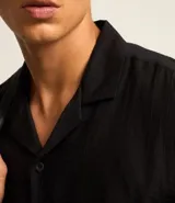 Camisa de hombre color verde claro, corte slim, de manga corta y cuello inglés. Confeccionada en viscosa texturizada.
