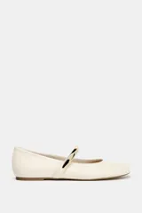 Zapato tipo bailarina color crema con tira sobre el empeine y aplique metálico dorado.