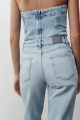 Pantalón de jean celeste de corte recto y largo, con tiro medio y cinco bolsillos.