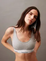 Conjunto Calvin Klein Modern Cotton gris melange, compuesto por corpiño deportivo con breteles anchos y bombacha clásica. Ambos con banda elástica blanca con logo de la marca.