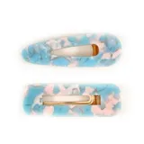 Set de dos broches para el pelo, uno con forma rectangular y otro con forma de gota. Ambos broches tienen un diseño abstracto en tonos celeste, rosa y blanco, con un pasador metálico dorado.