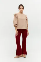 Blusa color rosa pálido de algodón con mangas cortas abullonadas y volados en el escote.