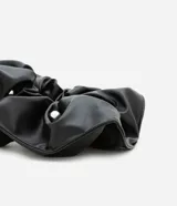 Coletero negro de cuero sintético con tachas plateadas.