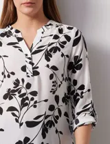 Blusa de gasa estampada con flores, marca Zac & Rachel. Tiene cuello a la base, escote en V y abertura con botones. Las mangas largas son de largo regulable.