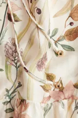 Vestido largo de viscosa con estampado floral, corte holgado, cuello redondo con botones y mangas globo largas. Incluye cinturón fino para atar.