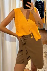 Minifalda marrón con diseño cruzado y lazo en la cintura.