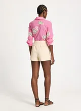 Short pollera color beige claro, con corte cruzado y lazo lateral.