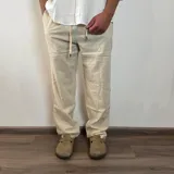 Pantalón de lino color beige, de corte recto, con cintura ajustable con cordón.