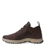 Bota de cuero para hombre marca Caterpillar, modelo Fudge Bar, en color marrón. Presenta un diseño de caña media con cordones, suela de goma beige con relieve antideslizante y detalles de gamuza en la zona del tobillo.