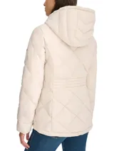 Campera acolchada color crema, con capucha, cierre de cremallera frontal, bolsillos laterales y logo de Tommy Hilfiger en la manga izquierda.
