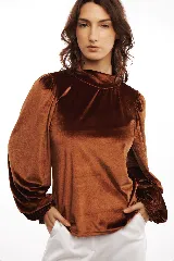 Polera de terciopelo color marrón con cuello alto y mangas largas abullonadas con puños elásticos.