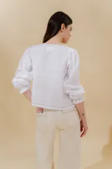 Blusa color beige de lino 100% con mangas balloon y detalle de tablón en el hombro. Tiene mangas largas con detalle de 2 pespuntes elásticos en contratono, el recurso del elástico es ideal para remangarse la manga generar más volumen. Calce recto, largo por arriba de la cadera.