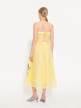 Pollera larga hasta los tobillos, confeccionada en organza color amarillo pálido. Presenta cintura elastizada y flores de tela aplicadas a mano en el delantero.