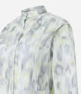Camisa de tricolina con estampado abstracto en tonos gris, blanco y amarillo. Tiene cuello padre, abotonado delantero y mangas largas con puños abotonados.