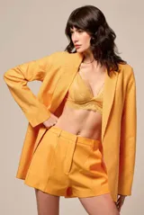 Blazer color mostaza con textura de lunares, solapas clásicas y forro interno.