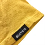 Remera color mostaza con logo de la marca Etnies estampado en el pecho.