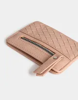Tarjetero color fucsia de cuerina con diseño trenzado en la parte inferior y cierre superior con tirador.