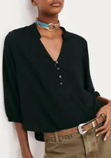 Blusa color verde claro, de mangas 3/4 con elástico en los puños, escote en V con botones y corte holgado.
