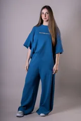 Conjunto azul de tejido de punto, compuesto por un sweater de mangas cortas con cuello redondo y un pantalón palazzo de cintura elastizada.