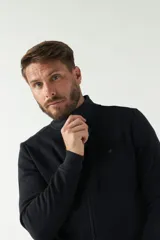 Campera negra de felpa con cierre frontal, bolsillos laterales, puños y logo bordado en el pecho.