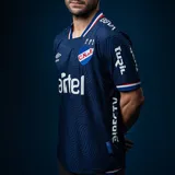 Camiseta de fútbol Umbro del Club Nacional de Football, modelo Away 2 2025. Diseño azul marino con patrón de ondas en azul oscuro, detalles en rojo, escudo bordado, sponsors oficiales y logo Nacional del Mundo en la nuca.