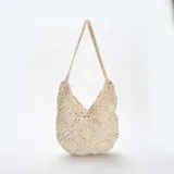 Bolso de hombro tejido a crochet en color crema, con diseño calado y asa larga.