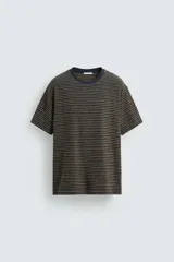 Camiseta de hombre de corte relaxed fit, con cuello redondo y mangas cortas. Diseño a rayas horizontales en tonos negro y dorado.