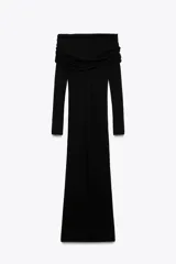 Vestido largo de punto negro con escote recto, hombros descubiertos, mangas largas y detalle de pieza metálica en el delantero.