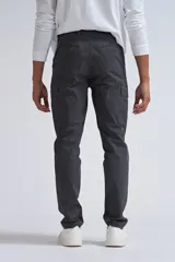 Pantalón cargo gris oscuro de corte slim, con bolsillos laterales con fuelle y solapa con botón a presión.