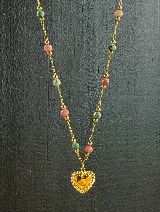 Collar con cadena de acero dorado, intercalando cuentas de piedra natural de rodocrosita (rosada) y turquesa africana (verde), con un dije central en forma de corazón dorado.