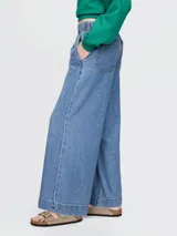 Pantalón de jean celeste, corte ancho, con cintura elástica y bolsillos laterales.