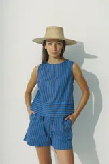 Top sin mangas de cuello redondo con estampado de rayas verticales en azul y negro, con detalle de franja horizontal en el bajo.