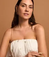 Vestido midi evasé sin mangas, confeccionado en tricolina color blanco, con escote recto con volantes y bordados metalizados de iconos.