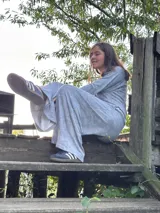 Conjunto color mostaza compuesto por un pantalón palazzo de corte evasé y una remera de manga larga con escote en V y bolsillo en el pecho.