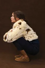 Chaqueta corta de piel sintética color crema con manchas marrones.
