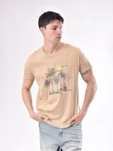 Remera color beige con estampado de palmeras y paisaje playero.