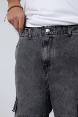 Pantalón jean azul de corte ancho, estilo cargo, con bolsillos laterales y detalles metálicos.
