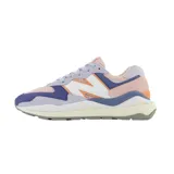 Championes urbanos New Balance modelo W5740, de mujer, con capellada de gamuza y malla en tonos lila, rosa, naranja y azul. Presentan el logo "N" característico en blanco con borde naranja y entresuela de goma blanca con suela gris.
