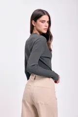 Polera gris oscuro de punto de rib con cuello alto y mangas largas.