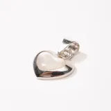 Dije en forma de corazón con base de plata 925 y una perla en el centro.