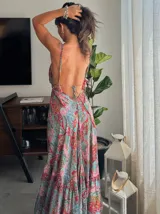 Vestido largo con estampado floral, escote halter y corte asimétrico con volados.