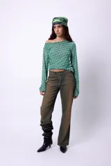 Top de microtul estampado con diseño a cuadros en tonos verde y azul, con escote asimétrico y mangas largas.
