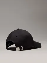 Gorra negra de algodón orgánico con logo CK metálico en el frente.