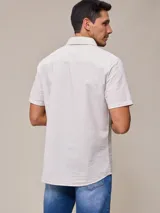 Camisa de manga corta con rayas verticales azules y blancas, confeccionada en algodón.