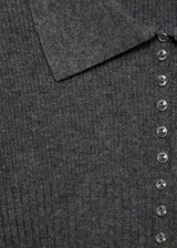 Jersey negro de punto fino con cuello camisero, diseño entallado y botones decorativos.