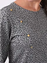 Remera negra de manga larga con cuello redondo y detalle de botones dorados en el hombro.