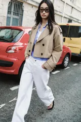 Jeans blancos de tiro medio con cinco bolsillos y pernera ancha. Cierre frontal con botones.