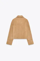 Chaqueta de mujer realizada en piel de ante color beige. Tiene cuello solapa, manga larga, bolsillos de plastrón en delantero y cierre frontal con botones.